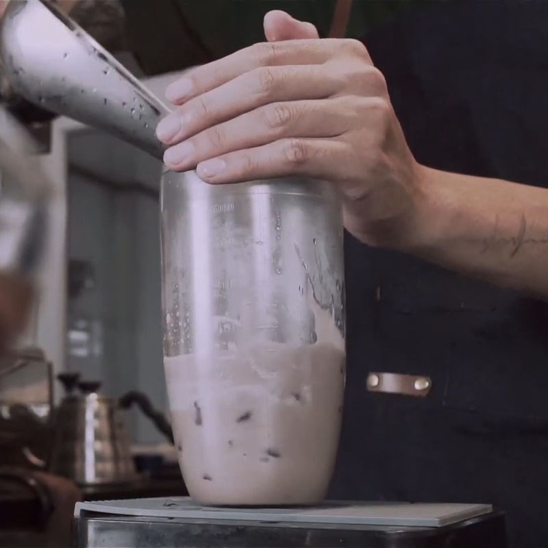 Lắc trà sữa khoai môn trong bình shake cùng đá viên, tạo độ lạnh và hòa quyện hương vị.