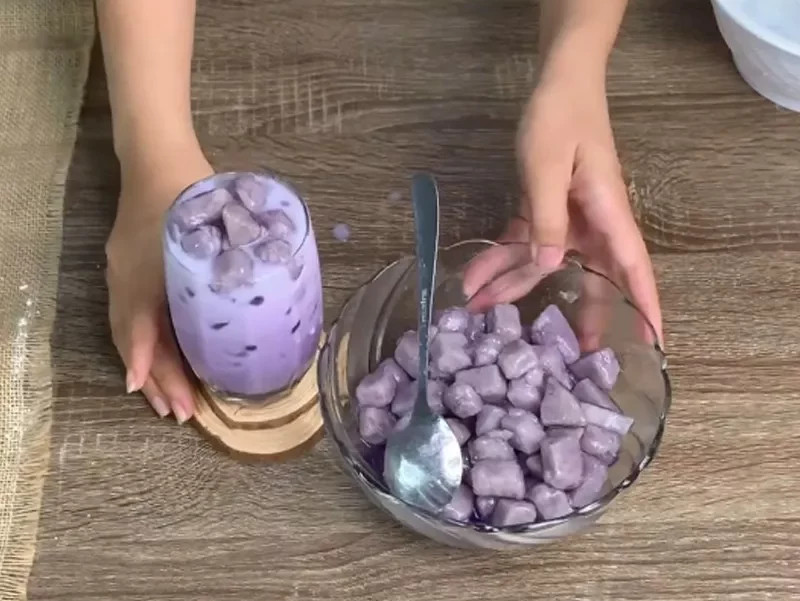 Ly trà sữa khoai môn tươi màu tím đẹp mắt với trân châu và đá viên mát lạnh, biểu tượng của sự pha chế tại nhà.
