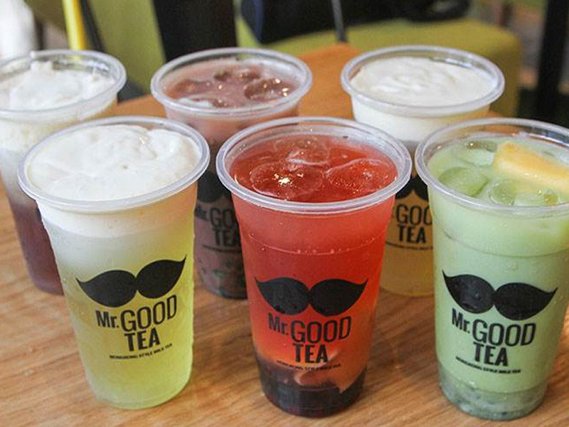 Ly trà sữa Mr Good Tea với topping trân châu và thạch, đặt trên bàn gỗ