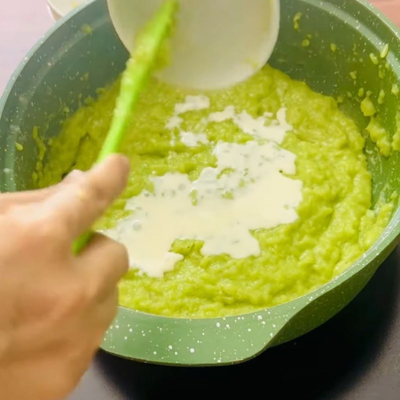 Thêm màu thực phẩm xanh bơ vào cốm đang nấu, tạo màu sắc hấp dẫn cho topping cốm dẻo